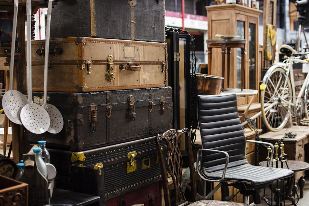 Valises, vélo, meubles anciens dans un espace encombré → ambiance débarras